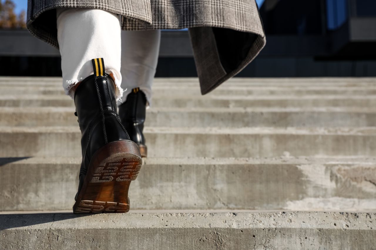 Cinq baskets montantes tendance en cuir, noir, blanc et bordeaux, sur sol urbain automne-hiver.